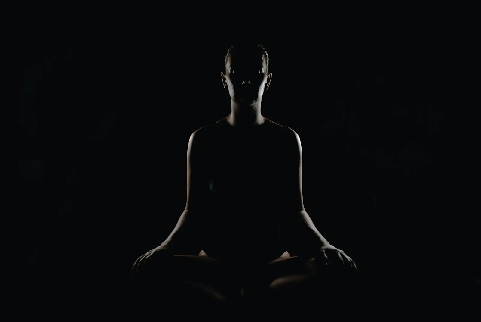 A person seated in a calm breathing practice, eyes closed, quiet and still