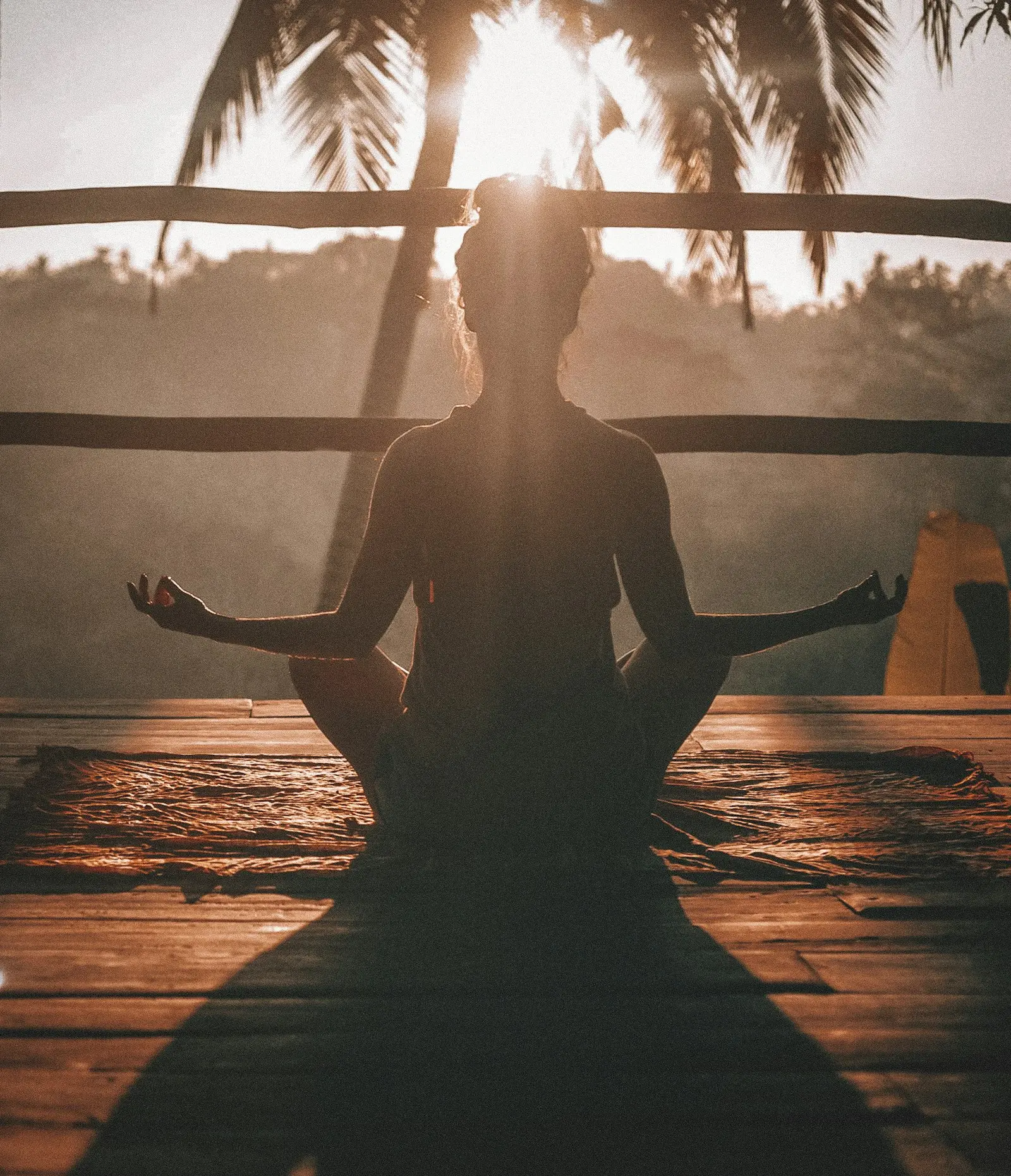 A person sitting in quiet meditation on a warm wooden floor, soft side light, unhurried