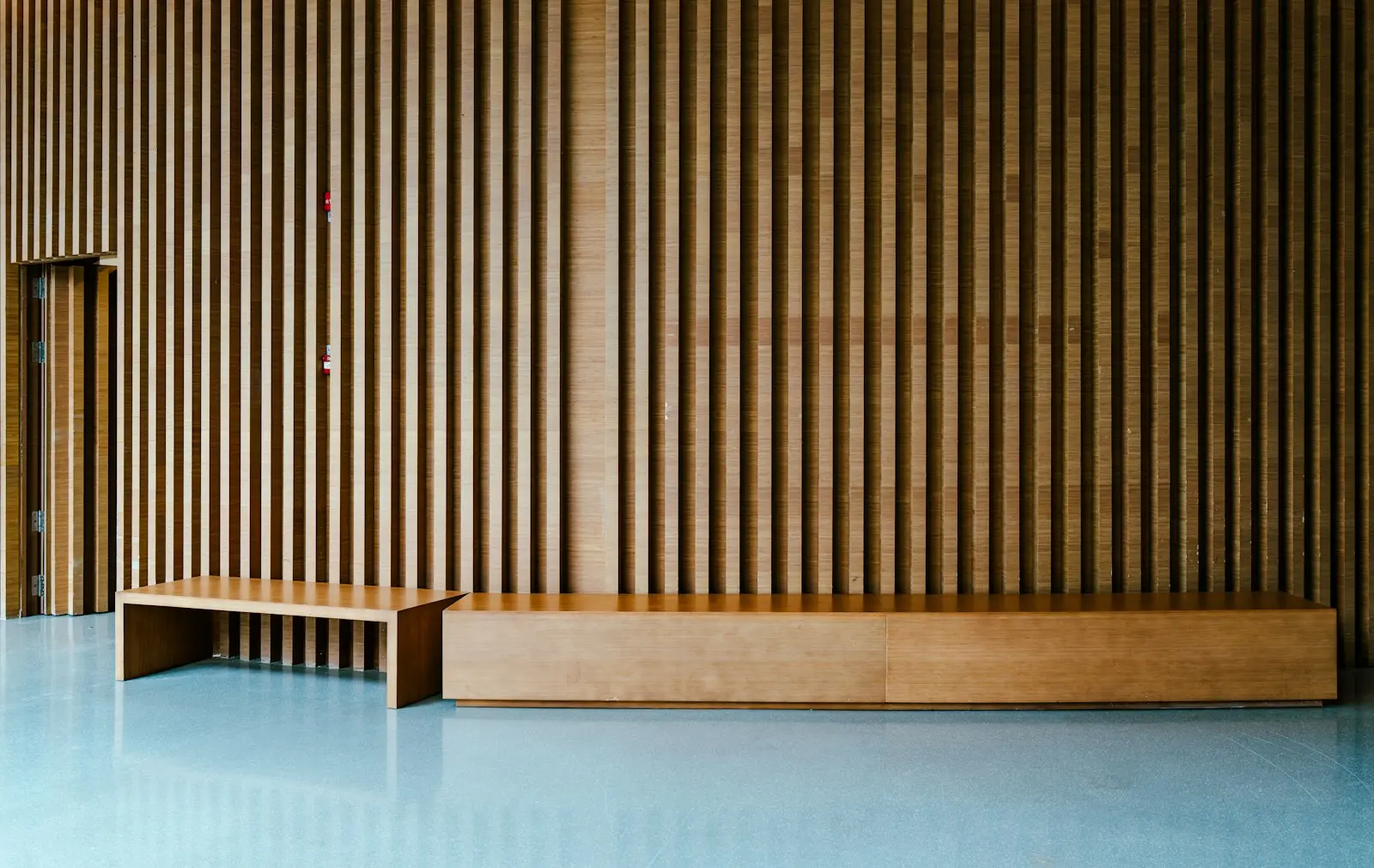 The warm wooden studio room with a slatted wall, soft daylight, calm and uncluttered
