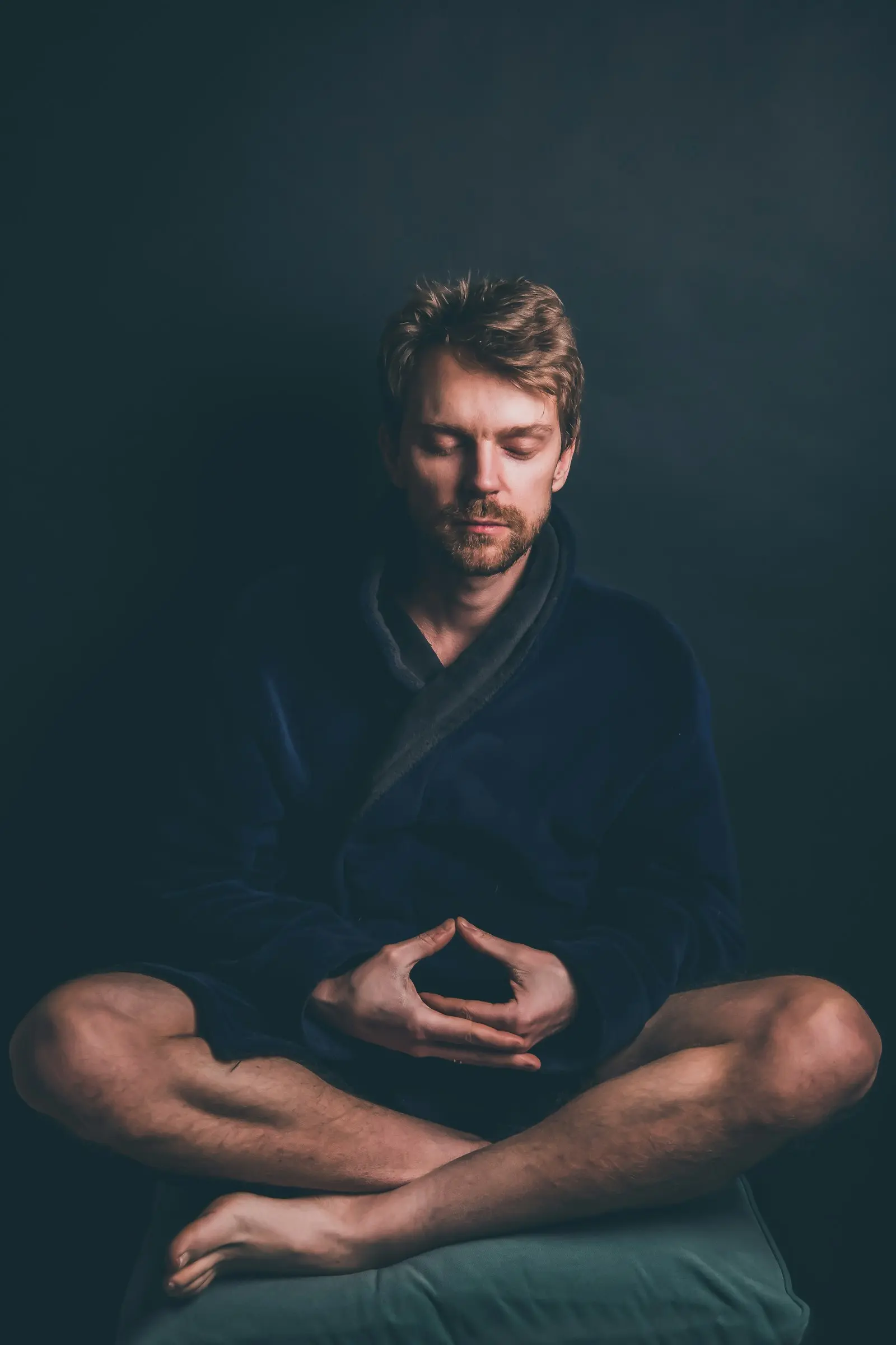 Portrait of Tom, a man seated and relaxed against a soft dark background, gentle expression